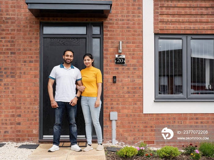 Portrait of couple standing on front porch