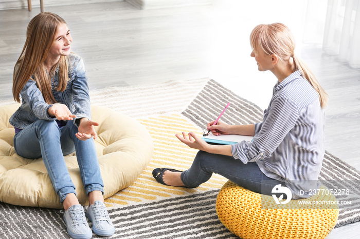 Female psychologist working with teenage girl in office