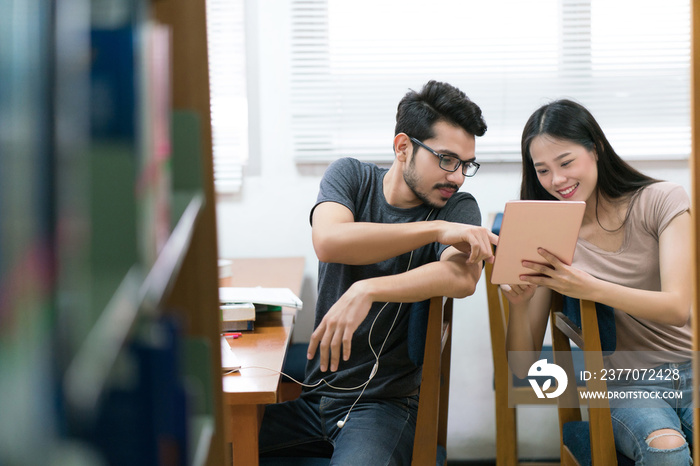 Asian students Helping each other study on tablet the knowledge in the library