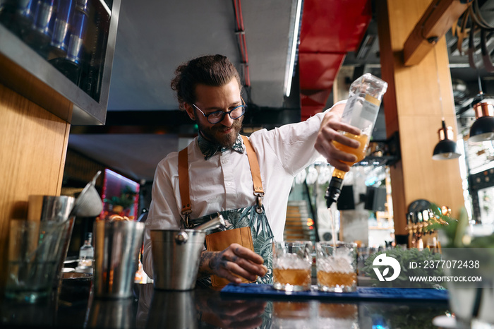 Happy barista making cocktails while working at nightclub.