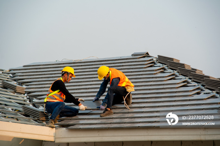 Roofer working on roof structure are installing new roof,Two roofers inspecting new roof.