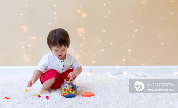 Little toddler boy playing with his toys