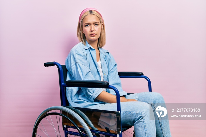 Beautiful blonde woman sitting on wheelchair depressed and worry for distress, crying angry and afraid. sad expression.