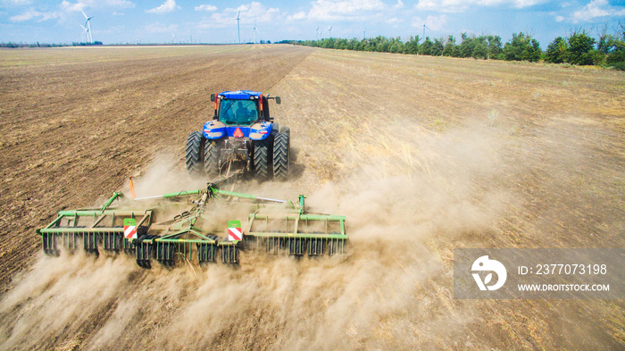 A tractor plowing and sowing in the field