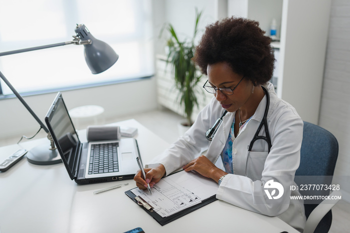 Serious concentrated African American doctor working in her office at clinic