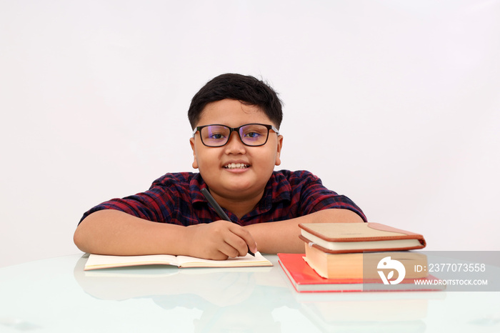Adorable asian school boy with eyeglasses studying over white background