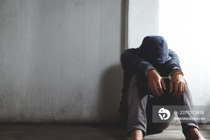 A male prisoner sitting stressed out in prison