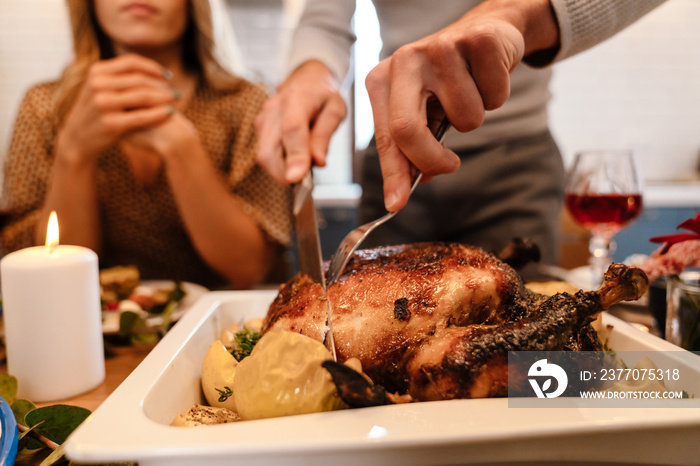 Multiracial happy friends eating turkey during thanksgiving dinner