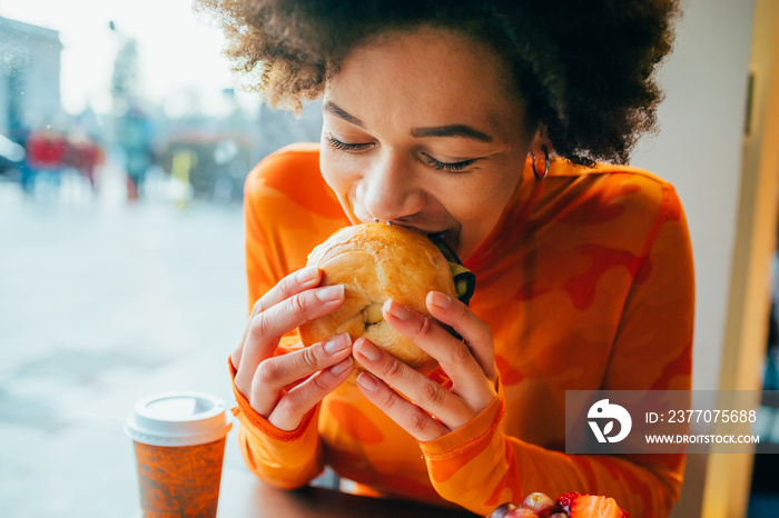 Close up of young woman eating hamburger