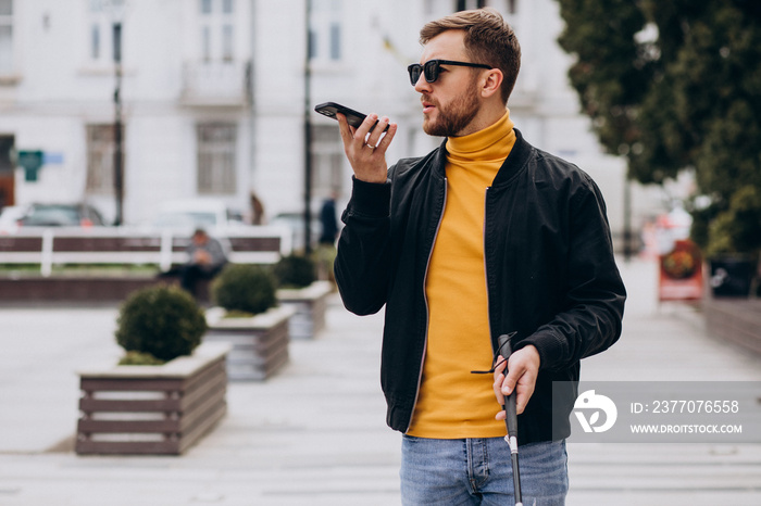 Young blinded man using phone and sending voice message