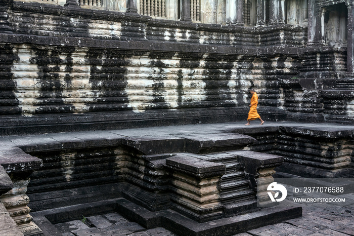 Young Buddhist monk walking outside temple in Angkor Wat, Siem Reap, Cambodia