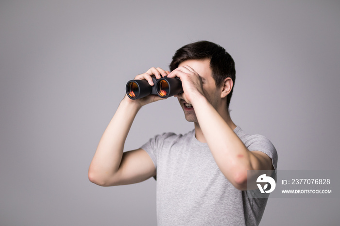 Young handsome man with binoculars isolated on white background