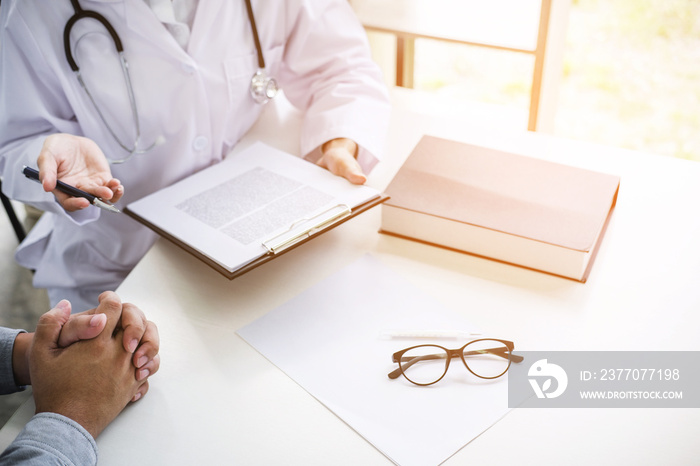 Doctor filling up an history form while consulting to patient and recommend treatment methods and how to rehabilitate