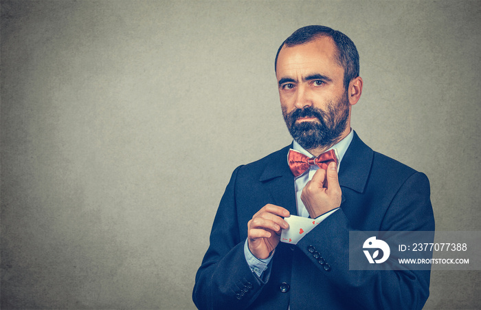 man pulling out a hidden ace card from suit jacket sleeve