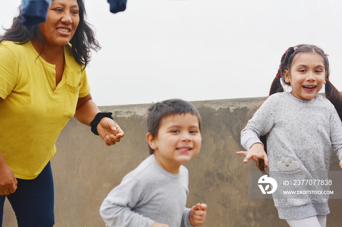 Playful portrait of indigenous South American woman with her two kids.