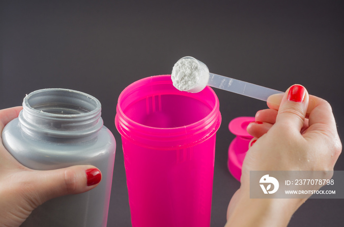 Mão de mulher dosando suplemento alimentar em shake