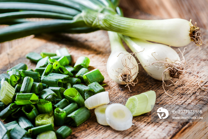 Young onion on wooden cut board in bunch fresh from healthy garden.