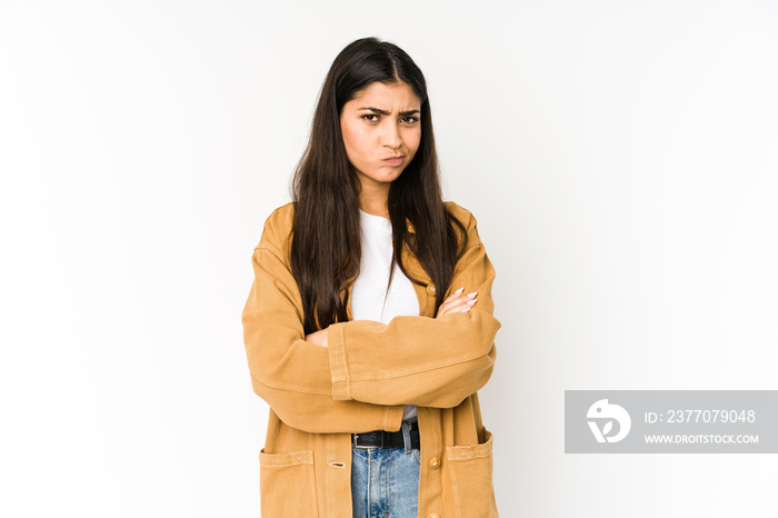 Young indian woman isolated on purple background frowning face in displeasure, keeps arms folded.