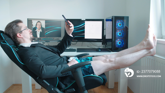 Man wearing business suit on video call from home in shorts