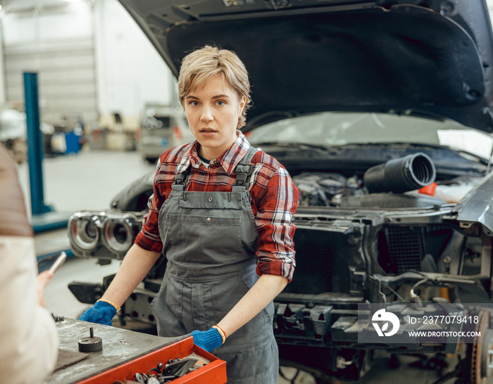 Woman standing in an auto repair shop