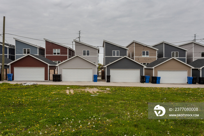 Row of colorful but generic houses and green grass