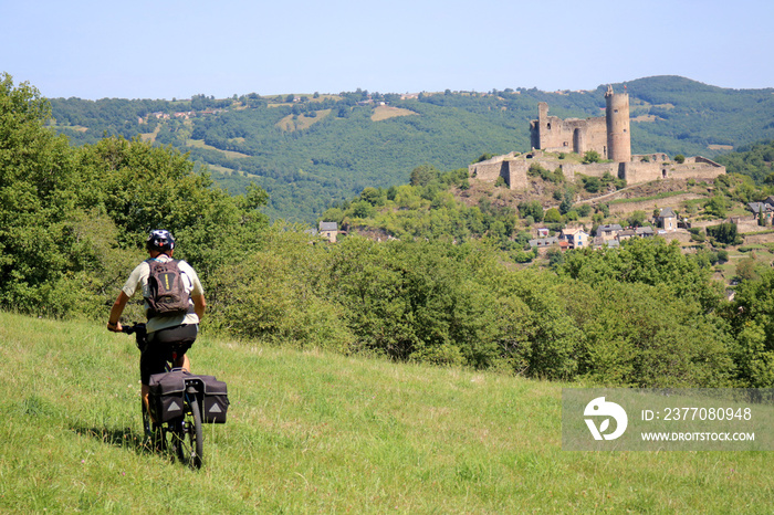 À vélo sur la colline du Bastit avec une vue sur la forteresse royale de Najac, Aveyron, France