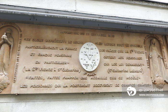 A slab of a miraculous medal on a wall at the entrance to the Miraculous Medal Church in Paris,