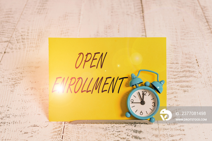 Writing note showing Open Enrollment. Business concept for policy of allowing qualifying students to enroll in school Alarm clock tilted above buffer wire in front of notepaper