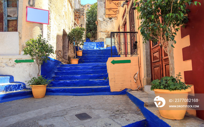 Ultramarine stairs with orange pots with trees. The picture taken in the town Symi, Greece