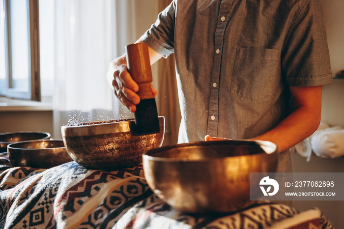 Spa with a masseur and a client who have a relaxing massage with Tibetan music bowls