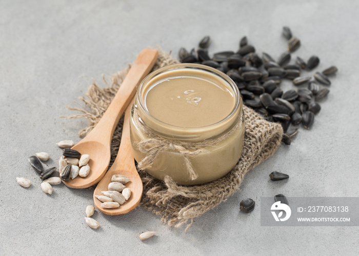 Sunflower paste in a jar in rustic style on a light background