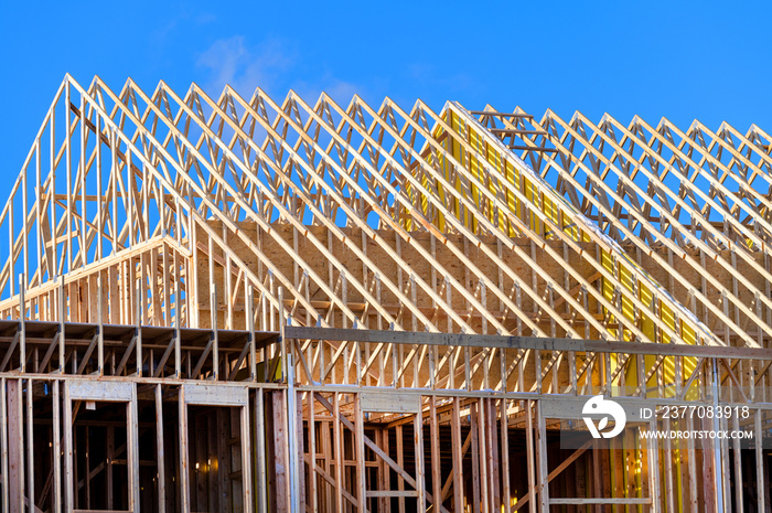 New residential construction home framing against a blue sky roofing construction