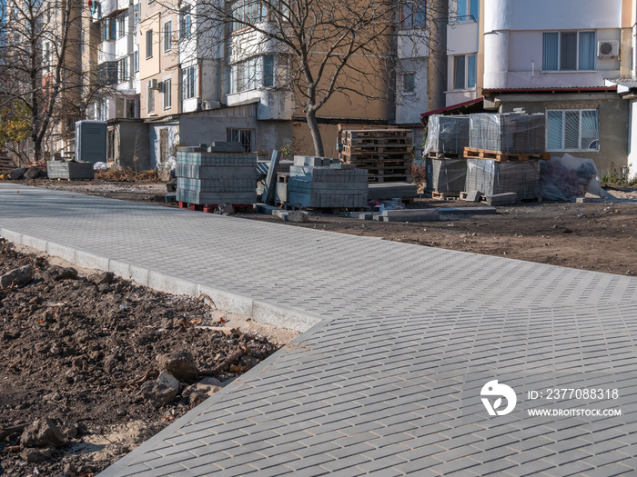 Repair of sidewalks and footpaths. Laying gray paving slabs.