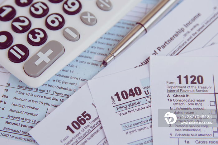 Tax season. calculator, pen on US tax form background