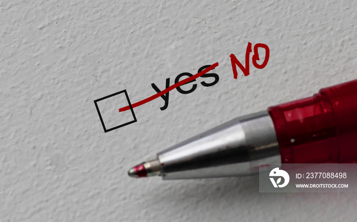 No - checkbox with a crossed out word yes on white paper with pen. Checklist concept.