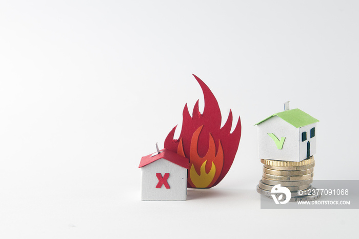 Fire insurance concept: two paper house, a flame and a pile of coins