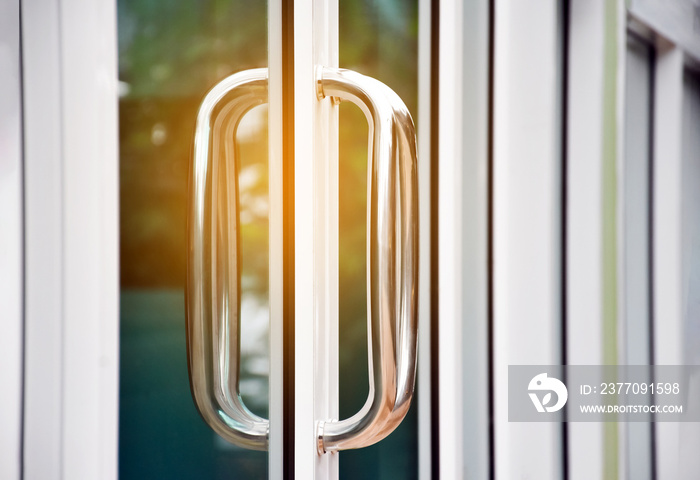 Closeup view of metal handle of glassdoor of the shop, soft and selective focus.