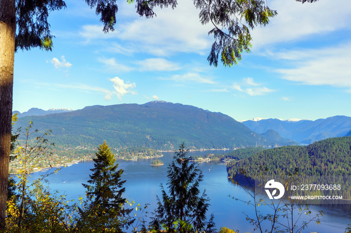 Tranquil waters of Burrard Inlet, BC, Canada, nestled among mountains, as seen from Burnaby Mountain Park, on a clear, crisp, Fall day.