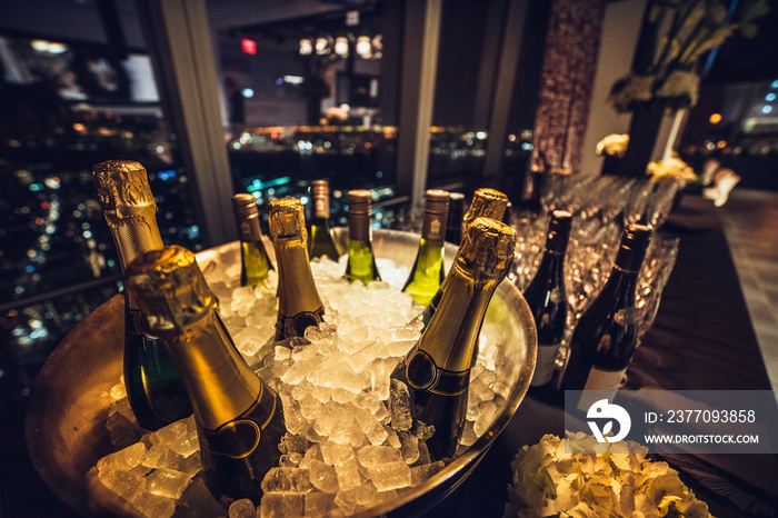 Champagne wine bottles on ice on catering table on luxury city eventt