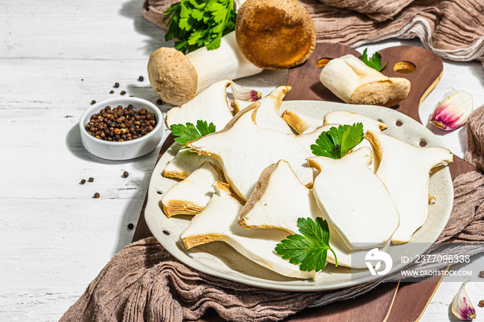 Fresh Pleurotus eryngii mushrooms on wooden background. Raw king oyster eringi with spices and herbs