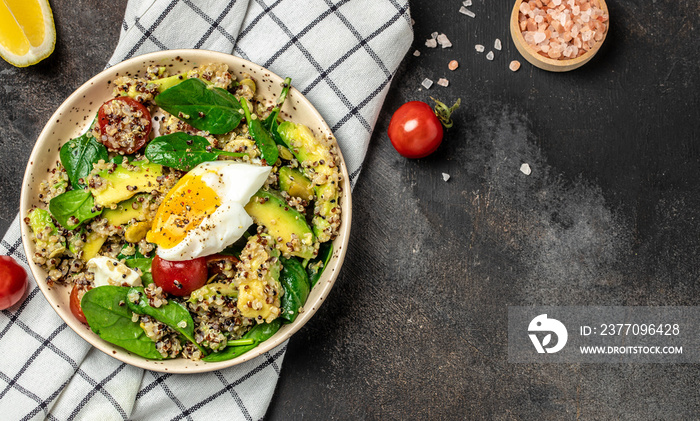 Quinoa buddha bowl with avocado, egg, tomatoes, spinach and sunflower seeds on a dark background. Homemade food. Healthy, clean eating. Vegan or gluten free diet, Long banner format. top view