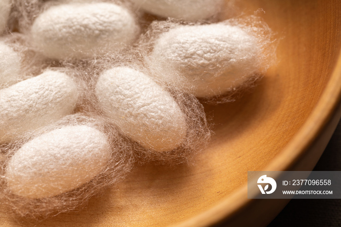 Close-up of silkworm cocoons in wooden dish. Silk close-up.