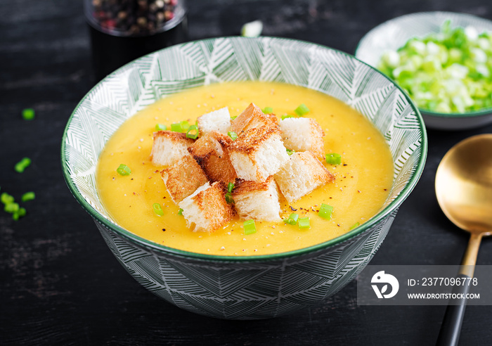 Creamy pumpkin puree soup with croutons, peppers and green onions.