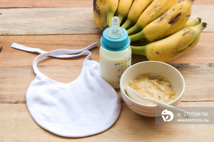 mashed banana healthy foods, milks in bottle of baby eats arrangement flat lay style on background wooden