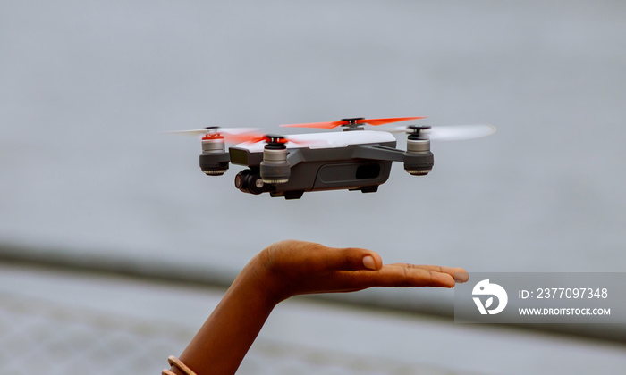 Little boy playing with drone in summer day outdoors.