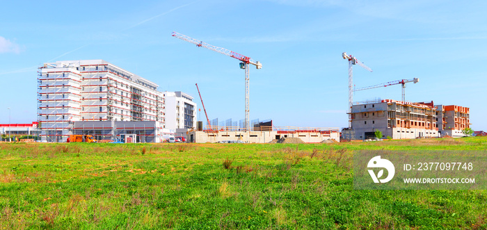 New construction site with cranes. Developer’s project on green field.