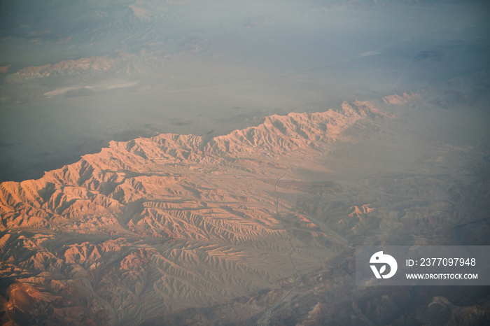 view from plane during flight over California mountains in sunset