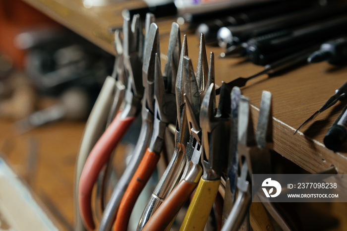 Front view of a set of various tools placed on a wooden desk in a workshop