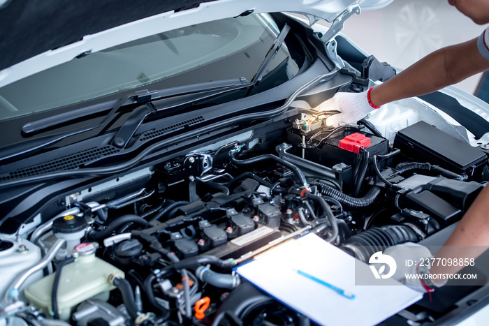 Auto mechanic (or technician) checking car engine at the garage