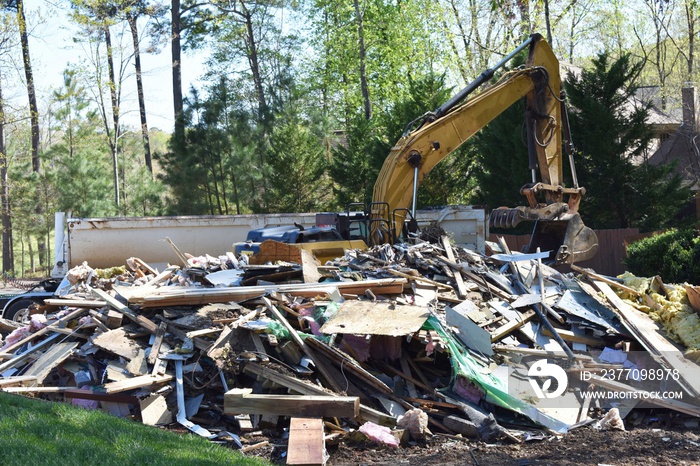 A backhoe picking up trash